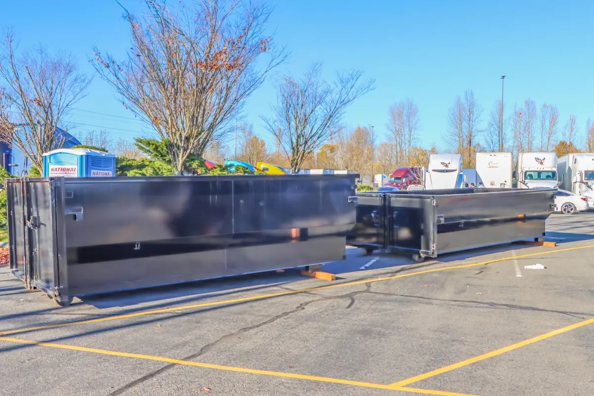 Professional dumpster rental service with roll-off container on residential driveway in Weston